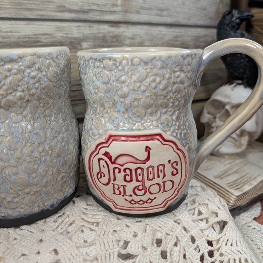 Ceramic mug with 'Dragon's Blood' design on a textured surface