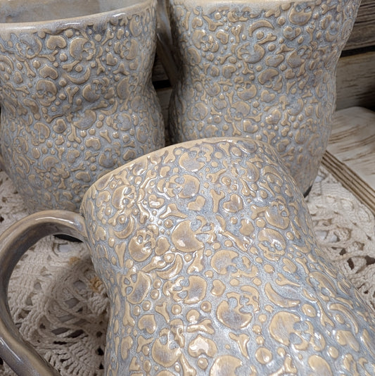 Close-up of textured ceramic pots on a woven surface