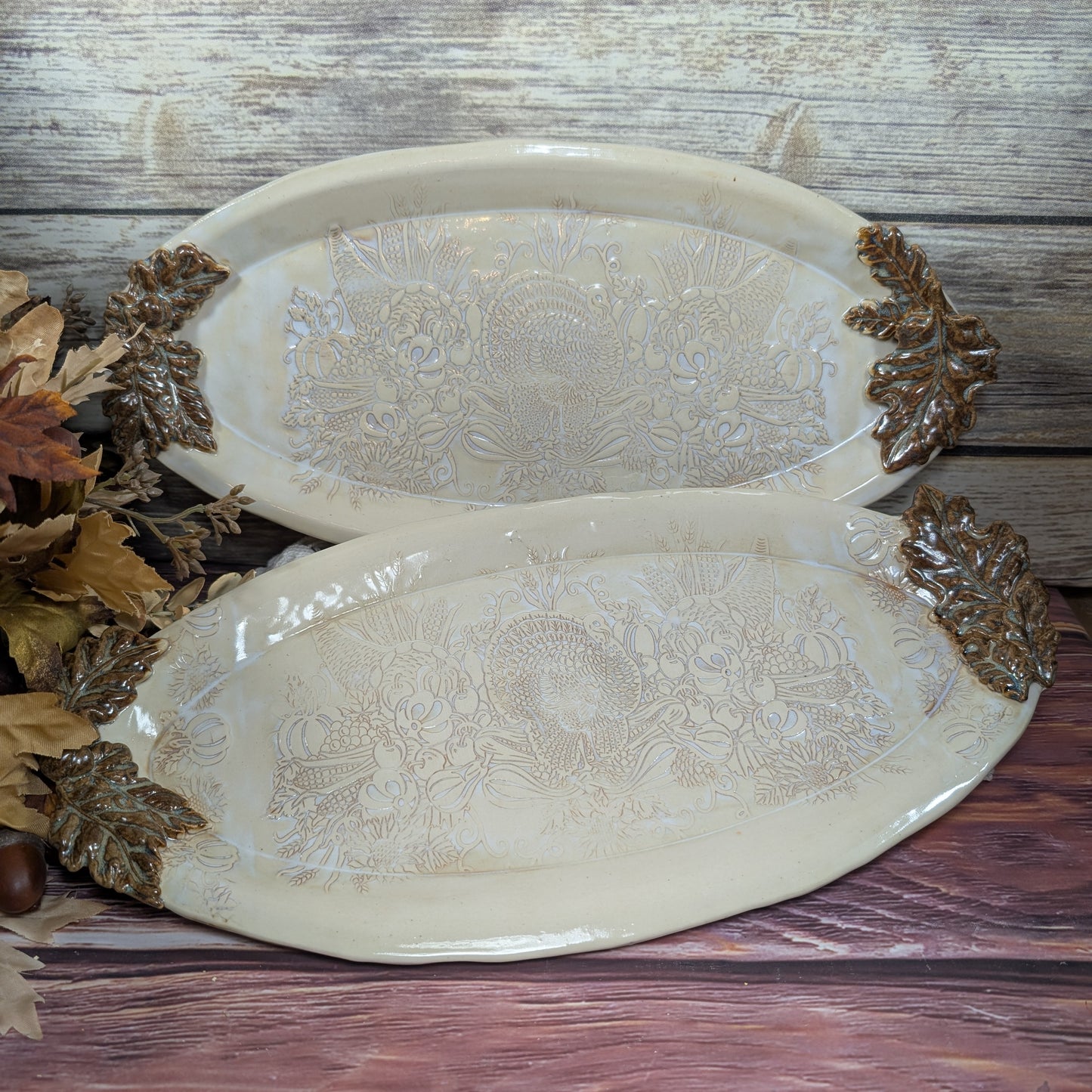 Decorative ceramic platters with embossed patterns on a wooden surface.