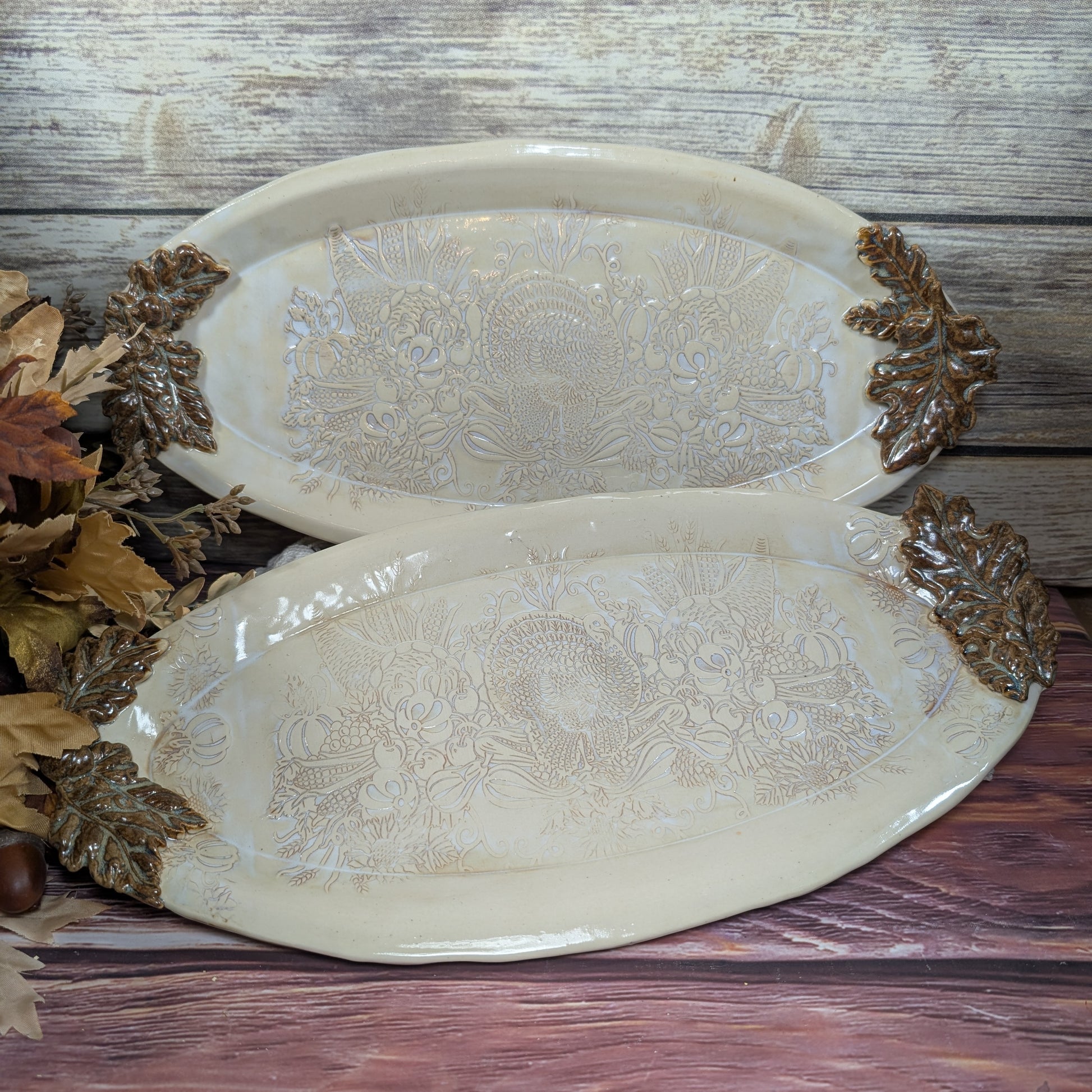 Decorative ceramic platters with embossed patterns on a wooden surface.