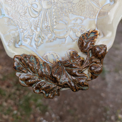 Decorative ceramic vase with leaf design and intricate patterns on a blurred background