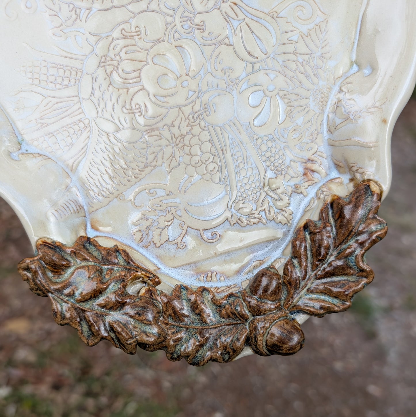 Decorative ceramic vase with intricate patterns and leaf design on a blurred background