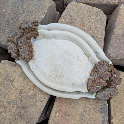 Decorative ceramic dishes with leaf designs on a rocky surface