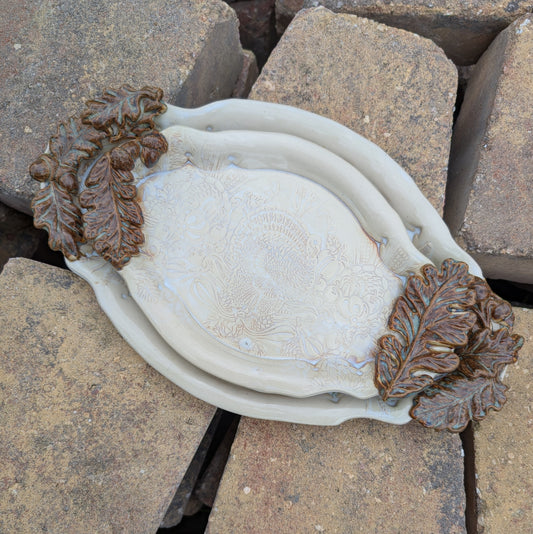 Decorative ceramic dishes with leaf designs on a rocky surface