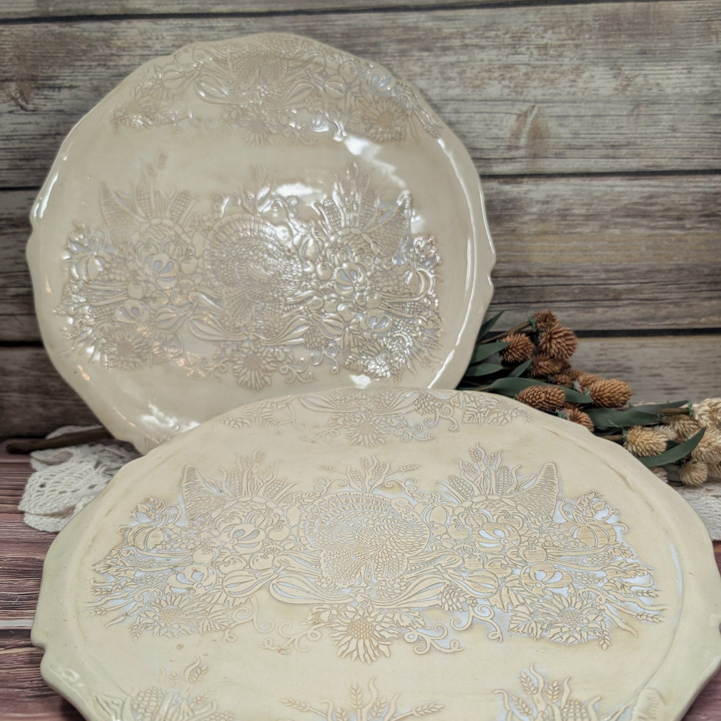 Two decorative plates with floral patterns on a wooden surface.
