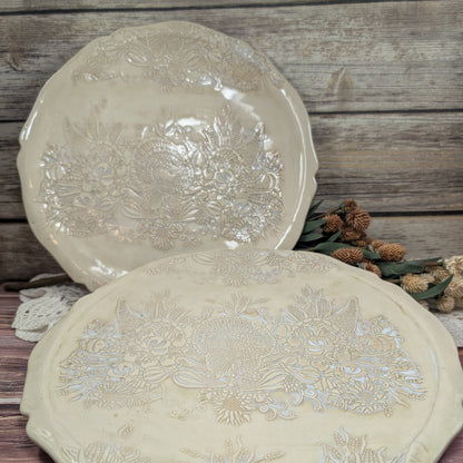 Two decorative plates with floral patterns on a wooden surface.