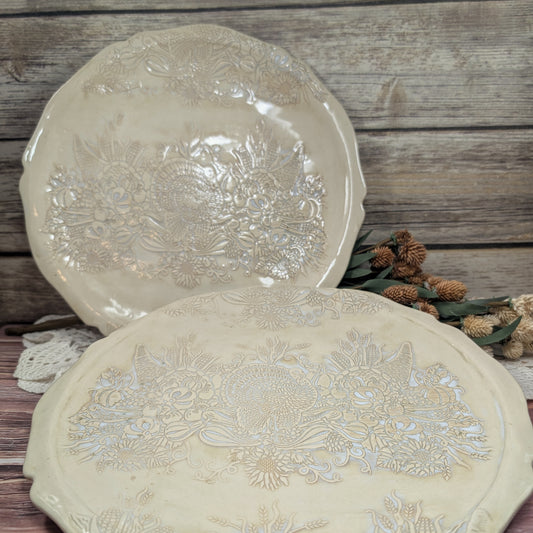 Two decorative plates with floral patterns on a wooden surface.