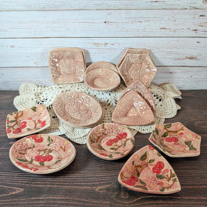Collection of decorative ceramic plates with floral patterns on a wooden surface.
