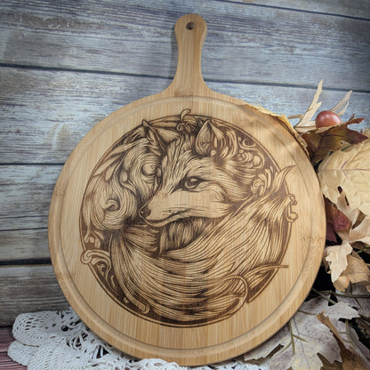 Wooden cutting board with engraved fox design on a rustic wooden background