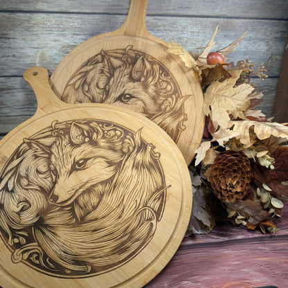 Two wooden cutting boards with fox engravings on a rustic background.