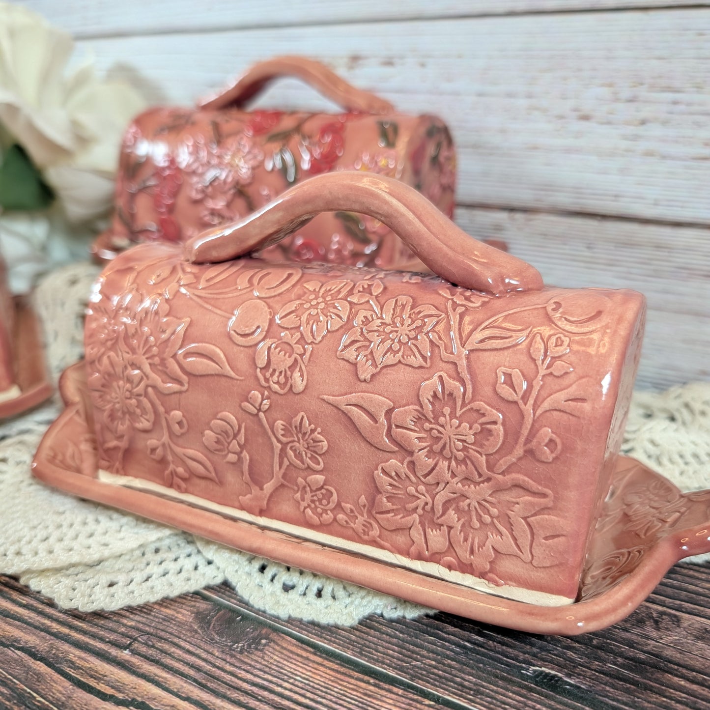 Ceramic butter dish with floral patterns on a wooden surface