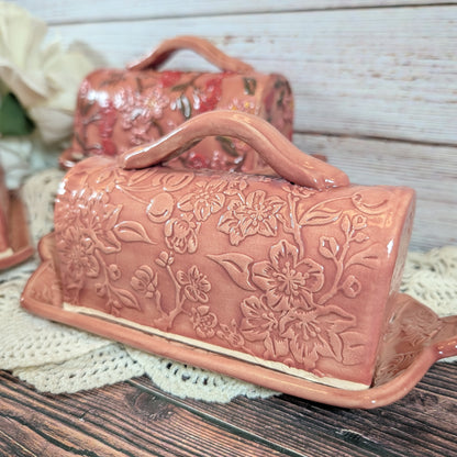 Ceramic butter dish with floral patterns on a wooden surface
